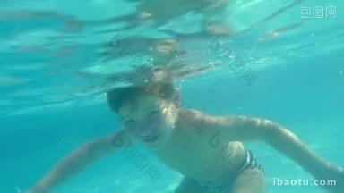 慢动作镜头小男孩游泳在游泳池和触摸相机<strong>水下</strong>